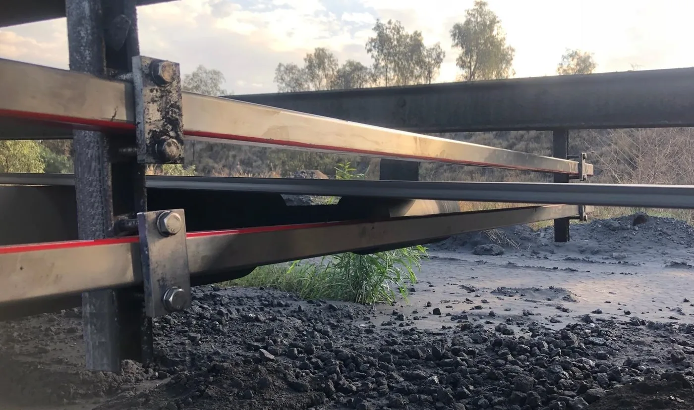 Two BSMF conditioning heads bolted to the conveyor structure, one above and one below the belt, marked red sides facing the belt.
